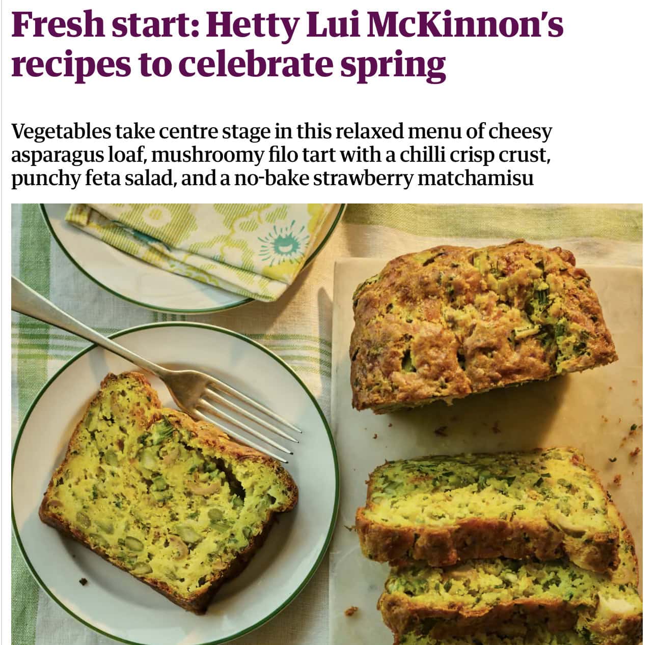 Sliced cheesy asparagus loaf on a wooden board with a knife, next to a plate with a piece of loaf on a table covered with green-patterned cloth. - Hetty Lui McKinnon