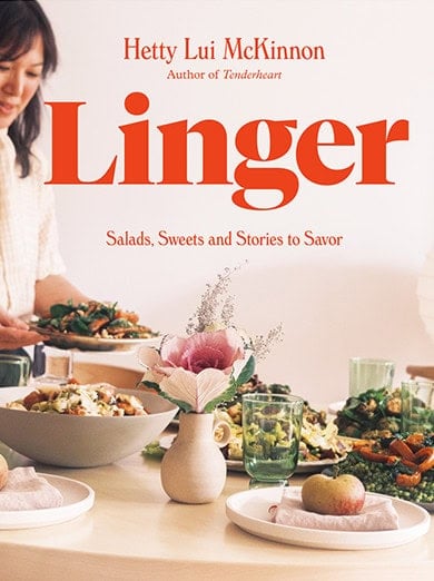 A woman sets a table with various salads and dishes, a floral centerpiece, and the book title "Linger" by Hetty Lui McKinnon is displayed in bold text.