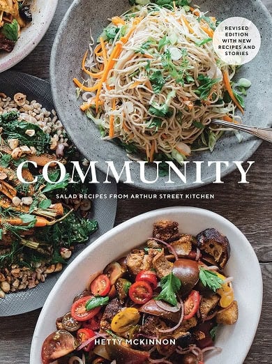 Cover of the book "Community" by Hetty McKinnon featuring three colorful salad dishes, with a revised edition label in the upper right corner.